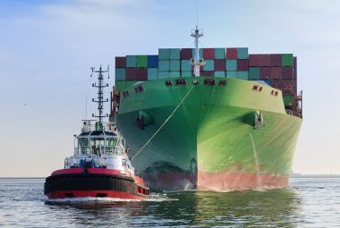 Tugboat towing cargo container ship