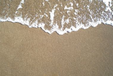 Wave of the sea entering the sand of the beach